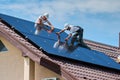 Workers building solar panel system on roof of house. Men installing photovoltaic solar module Royalty Free Stock Photo