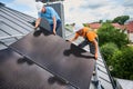 Workers building solar panel system on roof of house. Men installing photovoltaic solar module Royalty Free Stock Photo