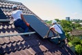 Workers building solar panel system on roof of house. Men installing photovoltaic solar module Royalty Free Stock Photo