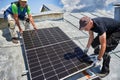 Workers building solar panel system on roof of house. Men installing photovoltaic solar module Royalty Free Stock Photo