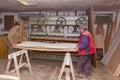 Workers in carpentry placed glued wooden profiles in the large clamp machine for pressing