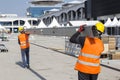 Workers carry construction metal pipes