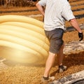 Workers carry a roll of yellow drainage pipe in their hands. Preparation for drainage works.