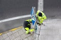 Workers changing a damaged road sign on street sidewalk