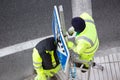 Workers changing a damaged road sign on street sidewalk Royalty Free Stock Photo