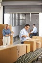 Workers Checking Goods On Belt In Distribution Warehouse Royalty Free Stock Photo