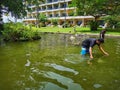 Workers cleaning a fish pond
