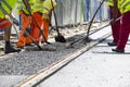 Workers construct asphalt road and railroad lines Royalty Free Stock Photo