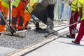 Workers construct asphalt road and railroad lines Royalty Free Stock Photo