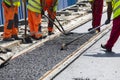 Workers construct asphalt road and railroad lines Royalty Free Stock Photo