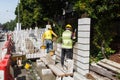 Workers constructing building noise barrier walls at busy highway