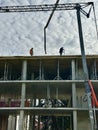 Workers at a construction site against the backdrop of the construction of a high-rise building. Builders work against the Royalty Free Stock Photo