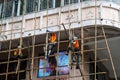 Workers on construction site building bamboo scaffolding on house facade in Hong Kong