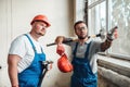 Workers at a construction site, one points with a finger at an object Royalty Free Stock Photo