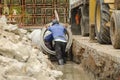 Workers control to put concrete pipe in groove