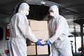 Workers in coronavirus hazmat suits delivering drugs