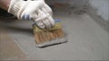 The process of applying mortar - waterproofing to a concrete floor. The concept of waterproofing the floor with a brush. Royalty Free Stock Photo