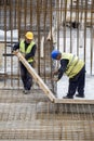 Workers with crowbar removes wooden formworks