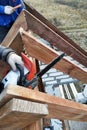 Workers cut the rafters on the roof of the chainsaw house