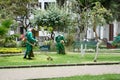 Workers cutting grass in a park