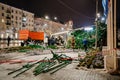 workers are dismantling a large artificial Christmas tree on a city street.