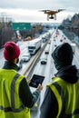 Workers with drone and tablet monitoring highway traffic in daylight.