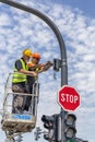 Workers at elevator platform installing city cctv security camera on the traffic light pole Royalty Free Stock Photo