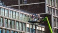 Workers on a elevator platform, repairs on a apartment complex in the city of Amsterdam, The Netherlands