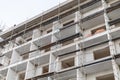Workers are engaged in construction tasks on a multi-story building. Scaffolding surrounds the structure, showing various stages Royalty Free Stock Photo