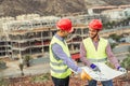 Workers engineers discussing about the new building area - Young builders reading the project in the construction site Royalty Free Stock Photo