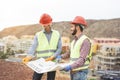 Workers engineers discussing about the new building area - Young builders reading the project in the construction site