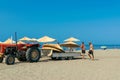 Workers equip the sand Long Beach (Velika plaza) with umbrellas brought on a tractor. Ulcinj, Montenegro. Adriatic Sea