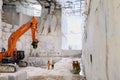 Workers and equipment inside Carrara marble quarry