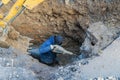 Workers excavate the pit with an excavator. Road repair.