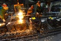 Workers in a foundry casting a metal workpiece - safety at work and teamwork Royalty Free Stock Photo