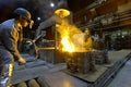 Workers in a foundry casting a metal workpiece - safety at work and teamwork