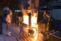 Workers in a foundry casting a metal workpiece - safety at work and teamwork Royalty Free Stock Photo