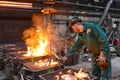 workers in a foundry casting a metal workpiece - safety at work and teamwork