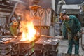 workers in a foundry casting a metal workpiece - safety at work and teamwork Royalty Free Stock Photo