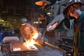 workers in a foundry casting a metal workpiece - safety at work and teamwork Royalty Free Stock Photo