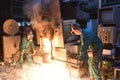 workers in a foundry casting a metal workpiece - safety at work and teamwork