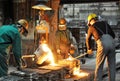 Workers in a foundry casting a metal workpiece - safety at work and teamwork