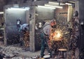 Workers in a foundry grind castings with a grinding machine - He Royalty Free Stock Photo