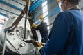 Workers handling equipment for lifting industrial boilers