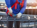 workers hands using steel wire and pincers to secure rebar