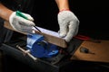 Workers hands on a wooden plank locked in the iron vise