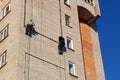 Workers hang the advertising on a building