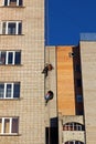 Workers hang the advertising on a building