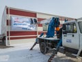 Workers hang an advertising poster with an appeal to come to the presidential election