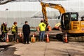 Workers in Hardhats Supervising Hole Digging